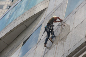 window cleaner hanging from high-rise building